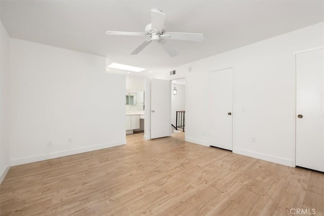unfurnished living room featuring a ceiling fan, light wood finished floors, and baseboards