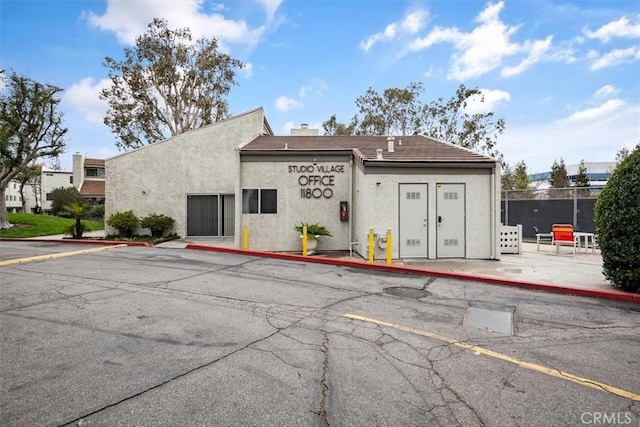 view of property with uncovered parking and fence