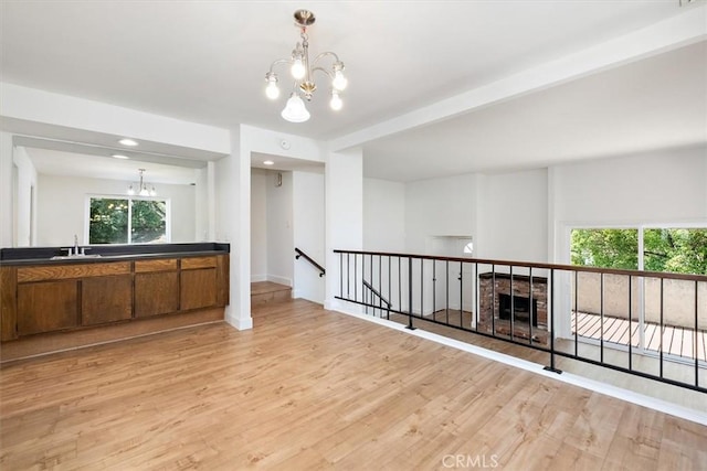 kitchen featuring a chandelier, brown cabinets, light wood-style flooring, and recessed lighting