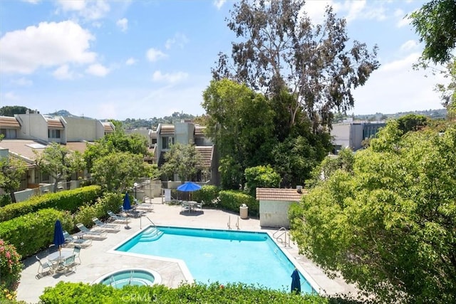 community pool with a hot tub and a patio area