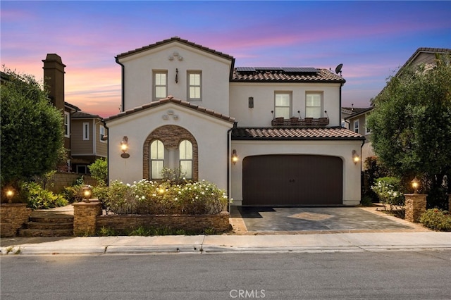 4067 Hoosier Lawn Way, Yorba Linda, CA 92886 - mediterranean / spanish-style house featuring a tile roof, a garage, roof mounted solar panels, stucco siding, and asphalt driveway