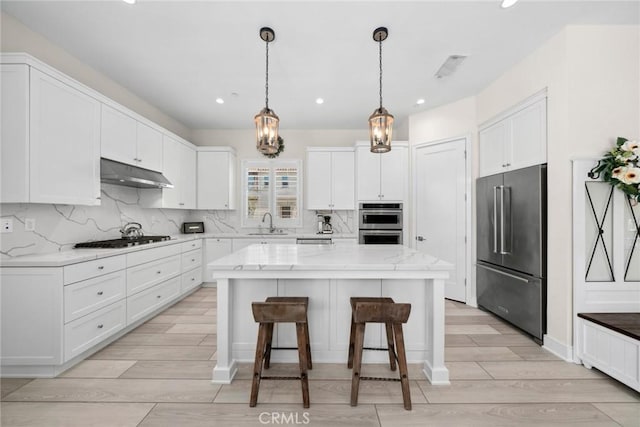 143 Trumpet Flower, Irvine, CA 92618 - kitchen with appliances with stainless steel finishes, under cabinet range hood, white cabinetry, a center island, and a sink