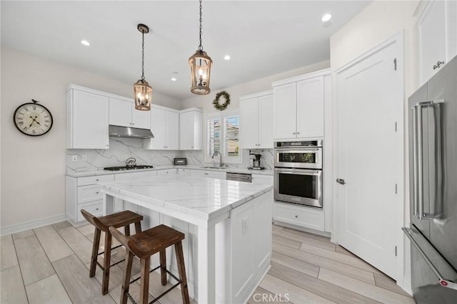 143 Trumpet Flower, Irvine, CA 92618 - kitchen featuring stainless steel appliances, tasteful backsplash, under cabinet range hood, light wood finished floors, and recessed lighting