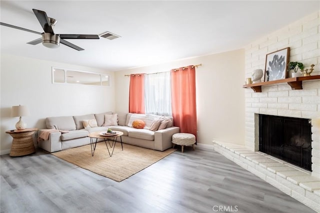 57966 El Dorado Dr, Yucca Valley, CA 92284 - living area featuring wood finished floors, ceiling fan, a fireplace, and baseboards