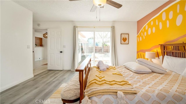 57966 El Dorado Dr, Yucca Valley, CA 92284 - bedroom with a textured ceiling, wood finished floors, access to outside, a ceiling fan, and baseboards