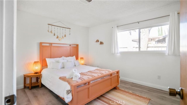 57966 El Dorado Dr, Yucca Valley, CA 92284 - bedroom with light wood-style floors, a textured ceiling, and baseboards