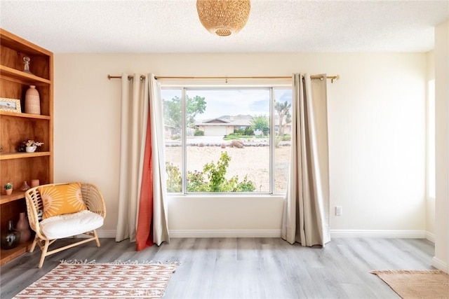 57966 El Dorado Dr, Yucca Valley, CA 92284 - living area featuring wood finished floors, a textured ceiling, and baseboards