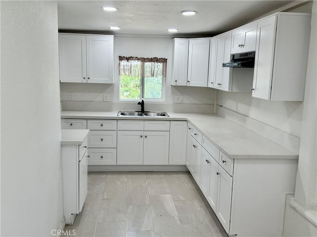 128 E 1st St, Buttonwillow, CA 93206 - kitchen with a sink, under cabinet range hood, white cabinetry, light countertops, and recessed lighting