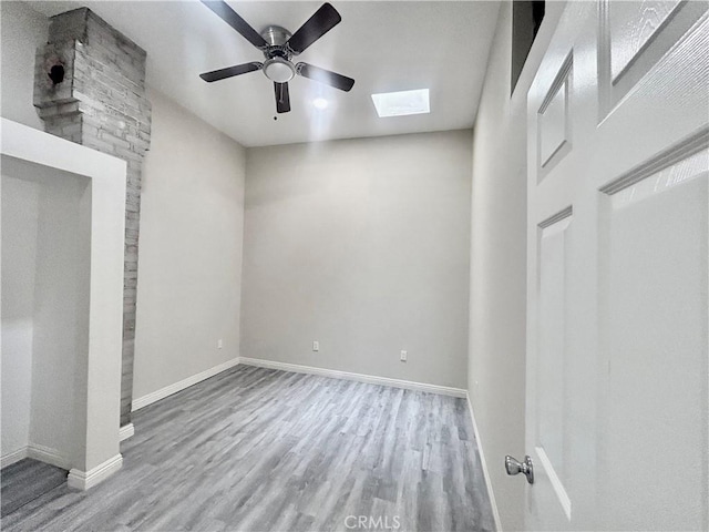 128 E 1st St, Buttonwillow, CA 93206 - unfurnished bedroom featuring a skylight, wood finished floors, baseboards, and a ceiling fan