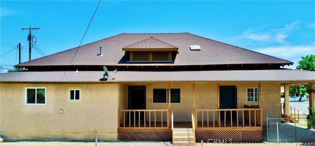 128 E 1st St, Buttonwillow, CA 93206 - back of property featuring a porch, stucco siding, and a shingled roof