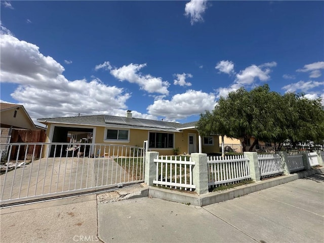 23610 David Ln Unit 1, Moreno Valley, CA 92557 - ranch-style house featuring stucco siding, solar panels, a fenced front yard, concrete driveway, and an attached garage