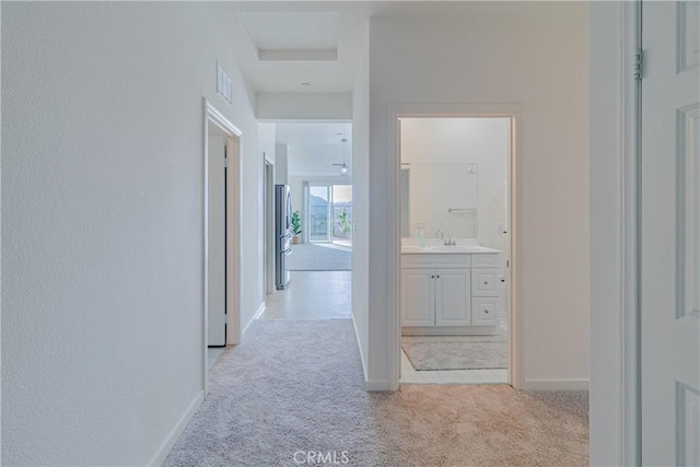 41207 Alegria Ln, Lake Elsinore, CA 92532 - corridor featuring a sink, light colored carpet, and baseboards