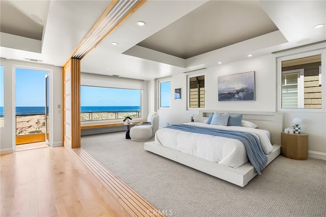 1554 E Oceanfront, Newport Beach, CA 92661 - bedroom featuring a raised ceiling, baseboards, a water view, recessed lighting, and wood finished floors