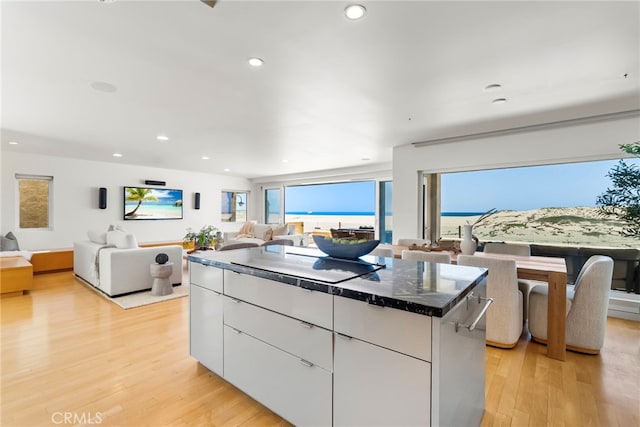 1554 E Oceanfront, Newport Beach, CA 92661 - kitchen with modern cabinets, light wood-type flooring, white cabinets, open floor plan, and a center island
