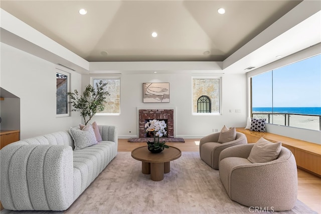 1554 E Oceanfront, Newport Beach, CA 92661 - living room featuring light wood-style flooring, a fireplace, plenty of natural light, a water view, and recessed lighting