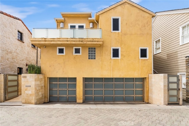1554 E Oceanfront, Newport Beach, CA 92661 - back of house with a balcony, stucco siding, an attached garage, and fence