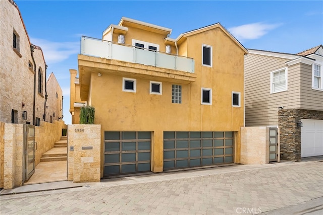 1554 E Oceanfront, Newport Beach, CA 92661 - view of front of property featuring stucco siding, a balcony, a garage, fence, and driveway