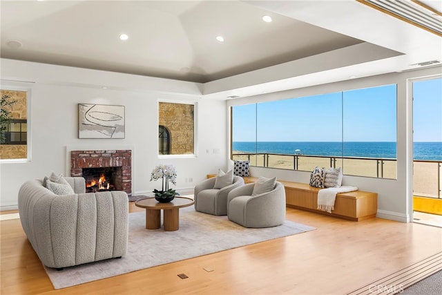 1554 E Oceanfront, Newport Beach, CA 92661 - living area featuring wood finished floors, a fireplace, a water view, baseboards, and recessed lighting