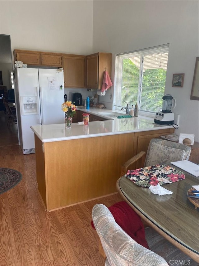 10815 Cherry Hls, Cherry Valley, CA 92223 - kitchen featuring white fridge with ice dispenser, a sink, brown cabinets, light countertops, and a peninsula