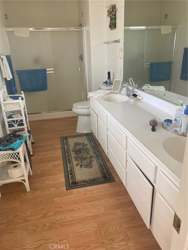 10815 Cherry Hls, Cherry Valley, CA 92223 - bathroom featuring wood finished floors, a stall shower, double vanity, and toilet