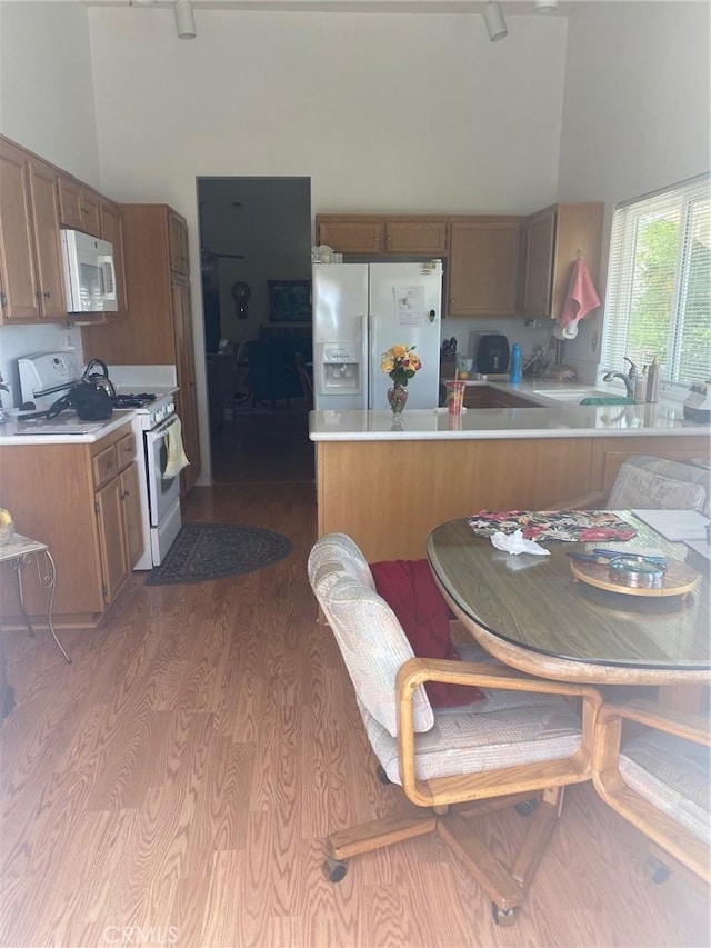 10815 Cherry Hls, Cherry Valley, CA 92223 - kitchen with white appliances, light countertops, a peninsula, dark wood finished floors, and a sink