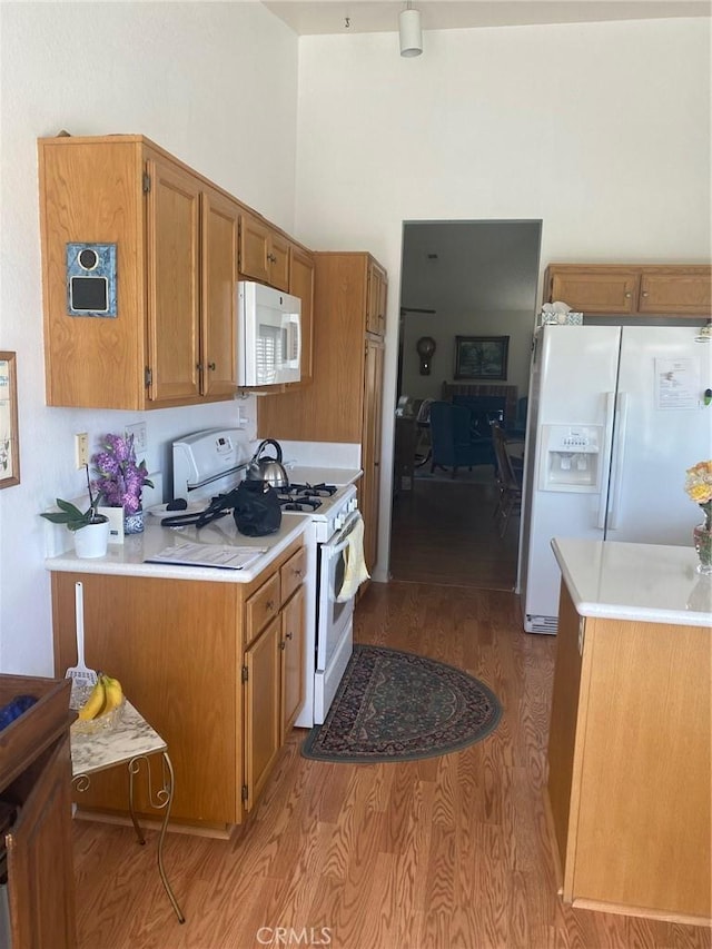 10815 Cherry Hls, Cherry Valley, CA 92223 - kitchen with white appliances, light wood finished floors, light countertops, brown cabinetry, and a towering ceiling