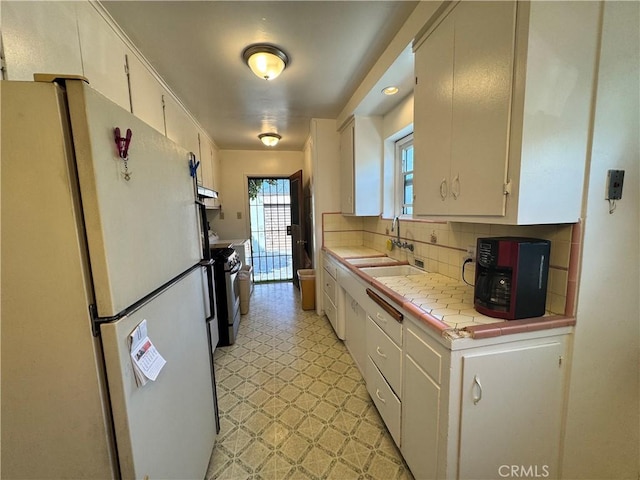 9529 Annetta Ave, South Gate, CA 90280 - kitchen featuring freestanding refrigerator, tile counters, backsplash, stainless steel gas range oven, and light floors