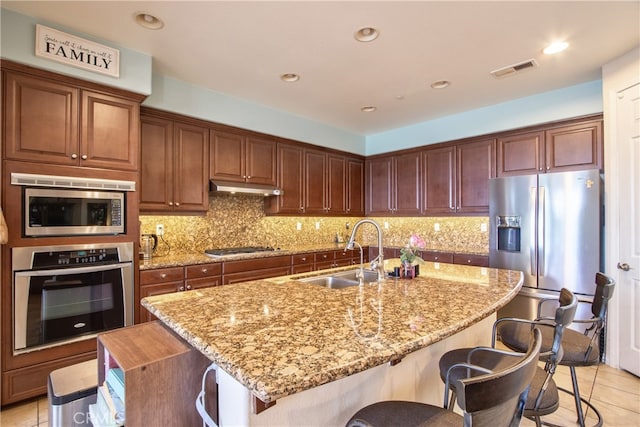 1931 James Gaynor St, Fallbrook, CA 92028 - kitchen featuring appliances with stainless steel finishes, a sink, under cabinet range hood, light tile patterned floors, and light stone counters