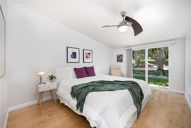 bedroom featuring light wood finished floors, baseboards, a ceiling fan, and lofted ceiling