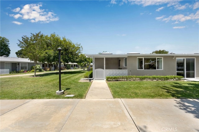 view of front of house with a front yard and stucco siding