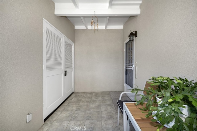 hall with a chandelier and a textured wall