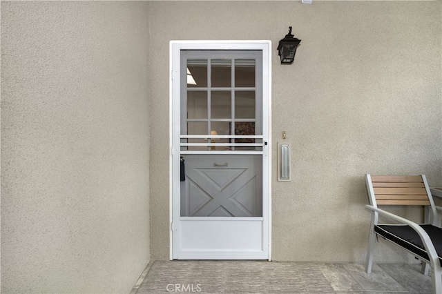 entrance to property with stucco siding