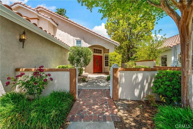 40686 Via Jalapa, Murrieta, CA 92562 - view of exterior entry featuring stucco siding, fence, and a tiled roof