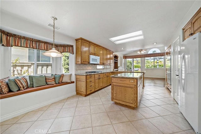 40686 Via Jalapa, Murrieta, CA 92562 - kitchen featuring white appliances, a skylight, healthy amount of natural light, and light tile patterned floors
