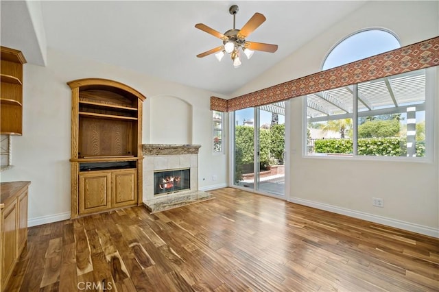 40686 Via Jalapa, Murrieta, CA 92562 - unfurnished living room with dark wood-style floors, ceiling fan, a tile fireplace, lofted ceiling, and baseboards