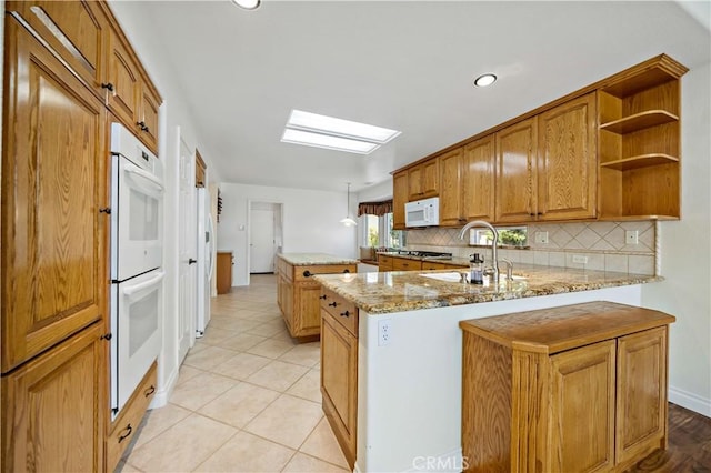40686 Via Jalapa, Murrieta, CA 92562 - kitchen with a sink, white appliances, decorative backsplash, a skylight, and a center island
