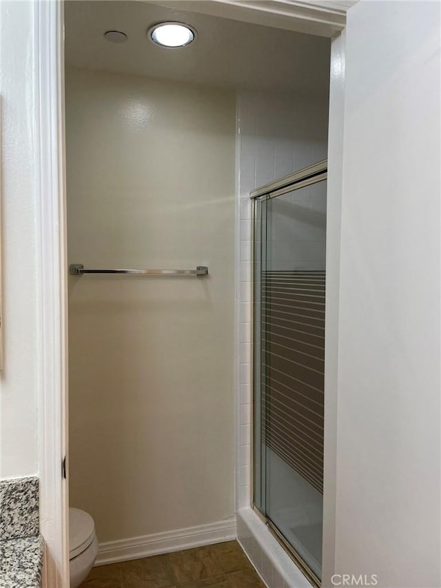 full bath featuring a stall shower, toilet, recessed lighting, tile patterned flooring, and baseboards
