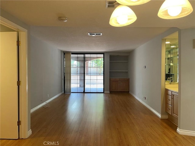 unfurnished dining area with light wood-style flooring and baseboards
