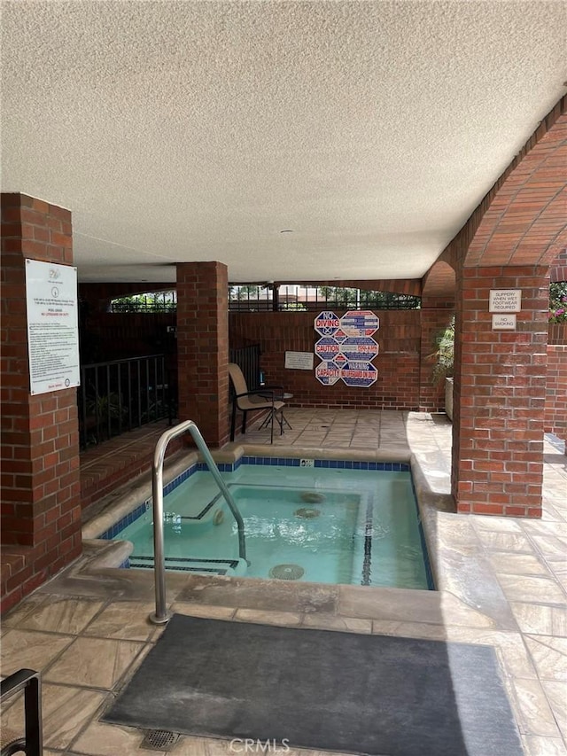 view of pool featuring an in-ground hot tub