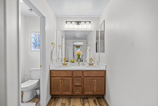 341 Dun Blazer Way, Fallbrook, CA 92028 - full bathroom with wood finished floors, double vanity, and toilet