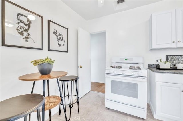 8873 Coolhurst Dr, Pico Rivera, CA 90660 - kitchen with gas range gas stove, white cabinetry, and light tile patterned flooring
