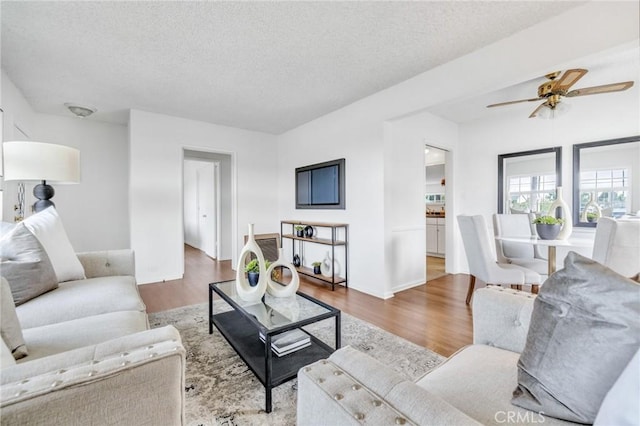 8873 Coolhurst Dr, Pico Rivera, CA 90660 - living area with wood finished floors, a textured ceiling, ceiling fan, and baseboards