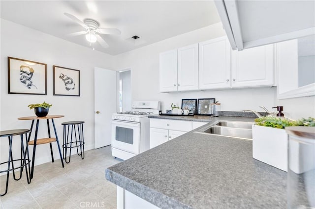 8873 Coolhurst Dr, Pico Rivera, CA 90660 - kitchen featuring white gas stove, ceiling fan, a sink, white cabinets, and beam ceiling