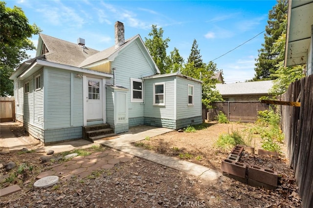 1725 Laurel St, Chico, CA 95928 - rear view of property featuring entry steps, a vegetable garden, a chimney, and a shingled roof