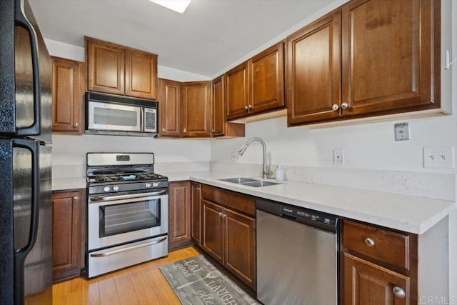 1278 E Madison Ave Unit D, El Cajon, CA 92021 - kitchen featuring appliances with stainless steel finishes, light wood-style floors, light countertops, and brown cabinetry