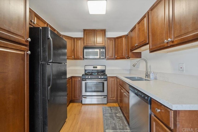 1278 E Madison Ave Unit D, El Cajon, CA 92021 - kitchen with stainless steel appliances, light wood-style floors, brown cabinetry, and light countertops