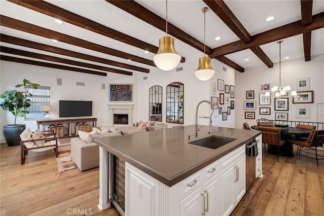 737 35th St, Manhattan Beach, CA 90266 - kitchen with a sink, dark countertops, light wood-style floors, white cabinets, and beamed ceiling