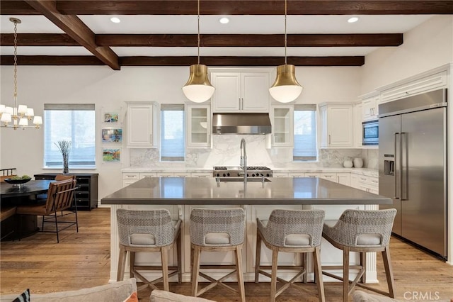 737 35th St, Manhattan Beach, CA 90266 - kitchen with built in appliances, under cabinet range hood, beam ceiling, decorative backsplash, and light wood-type flooring