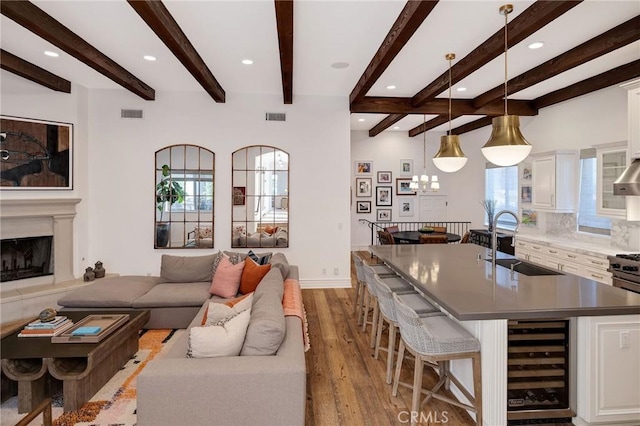 737 35th St, Manhattan Beach, CA 90266 - living area featuring beverage cooler, wood finished floors, recessed lighting, beam ceiling, and a fireplace with raised hearth