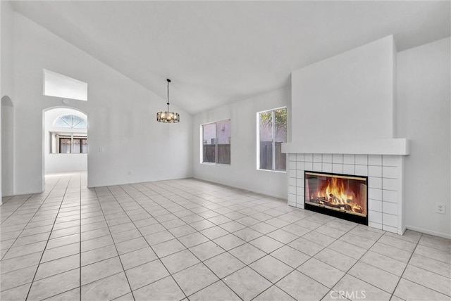 12820 Pan Am Blvd, Moreno Valley, CA 92553 - unfurnished living room featuring a chandelier, healthy amount of natural light, a tile fireplace, light tile patterned flooring, and high vaulted ceiling